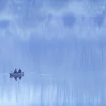 Deux Personnes dans un Bateau sur un Lac Calme