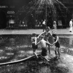 Enfants jouant sous une bouche d'incendie