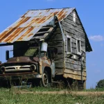 Camion abandonné transformé en maison de fortune dans un pré