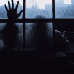 Silhouette d'une main sur une fenêtre givrée