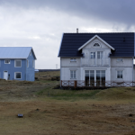 Deux maisons séparées dans un paysage rural nuageux