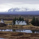 Village islandais pittoresque avec montagnes enneigées en arrière-plan