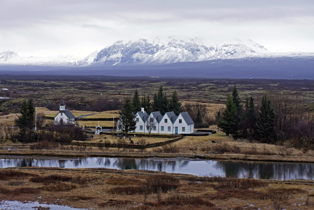 AKG2193097.webp Village islandais pittoresque avec montagnes enneigées en arrière-plan – Image 1