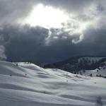Paysage Hivernal Enneigé sous un Ciel Nuageux