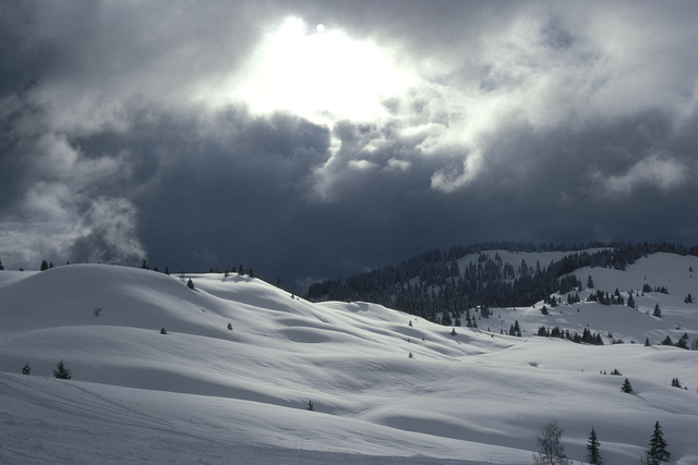 AKG2293977.webp Paysage Hivernal Enneigé sous un Ciel Nuageux – Image 1
