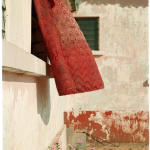 Tissu rouge flottant à la fenêtre d'un bâtiment délabré