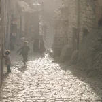 Enfants jouant dans une rue pavée d'un vieux quartier