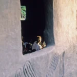 Vue à travers une fenêtre sculptée dans une maison africaine