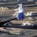 Pêcheurs préparant leurs filets sur des pirogues en bois