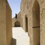 Personne en noir montant les escaliers d'un vieux bâtiment
