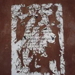 Affiche déchirée sur mur rouge