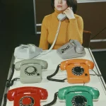 Femme au téléphone vintage parmi modèles colorés
