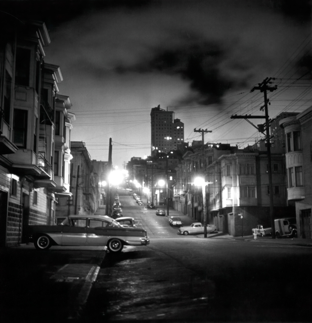 AKG239657.webp Rue urbaine en pente la nuit avec voitures anciennes – Image 1