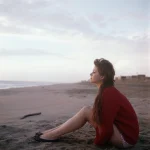 Femme pensive sur une plage au coucher du soleil
