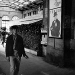 Homme marchant dans une gare ancienne