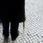 Personne âgée marchant sur un trottoir pavé