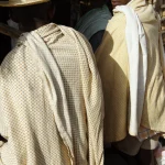 Deux hommes en chapeaux de paille discutant en extérieur.