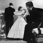 Femme en robe élégante avec éventail, regardant en arrière