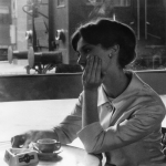 Femme au café devant un train