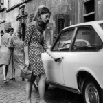 Femme ouvrant la porte d'une voiture vintage dans une rue européenne