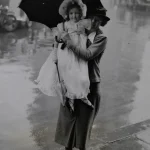 Femme tenant une jeune fille sous un parapluie par temps pluvieux