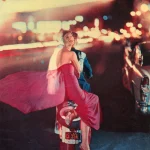 Couple à moto dans une ville illuminée de nuit