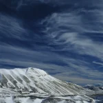 Montagne enneigée sous un ciel bleu nuageux