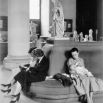 Femmes assises autour d'une statue dans un musée.