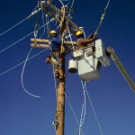 Électriciens travaillant sur un poteau électrique