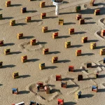 Plage avec cabines colorées et tour de surveillance.