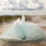 Éruption de geyser en Islande sous un ciel nuageux