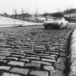 Voiture sur une route pavée enneigée