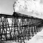 Train à vapeur traversant un viaduc en hiver