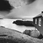 Maison en bois au bord de la mer avec des rochers