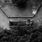 Homme allongé sur un banc dans un jardin