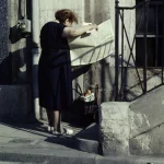 Femme lisant un journal sur un trottoir