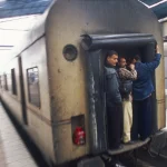 Voyageurs sur le Marchepied d'un Train en Mouvement