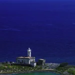 Phare côtier entouré par la mer et des collines