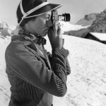 Femme prenant des photos dans un paysage enneigé