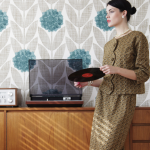 Femme élégante avec un disque vinyle devant un tourne-disque rétro