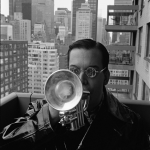 Trompettiste sur un balcon avec vue sur la ville