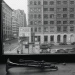 Trompette sur rebord de fenêtre avec vue urbaine en noir et blanc