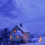 Maison isolée en montagne sous la neige en soirée