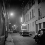 Rue de nuit avec voitures anciennes