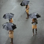 Marchants sous la pluie avec des parapluies noirs