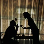 Silhouettes d'un homme fumant et d'une femme servant du café