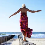 Femme marchant sur des poteaux en bord de mer