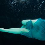 Femme nageant sous l'eau avec robe fluide