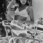 Femme en maillot de bain lisant sur une terrasse en été