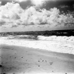 Plage déserte avec vagues et nuages